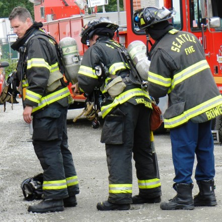 Firefighters help each other with their air bottles at the S. Monroe fire on June 18, 2012. (Photo by Lisa Swenson)